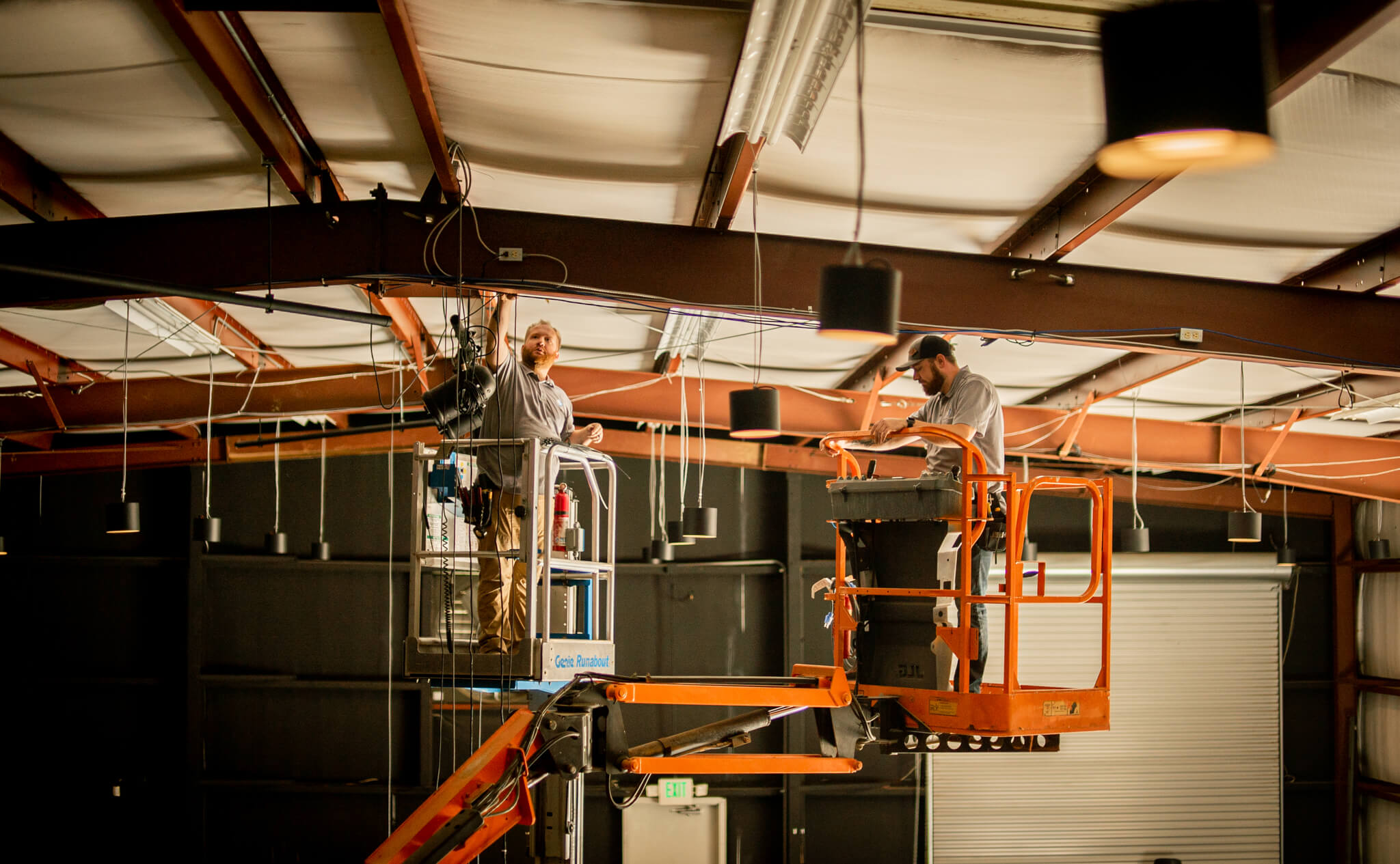Next Level Integration team on two lifts installing stage lights